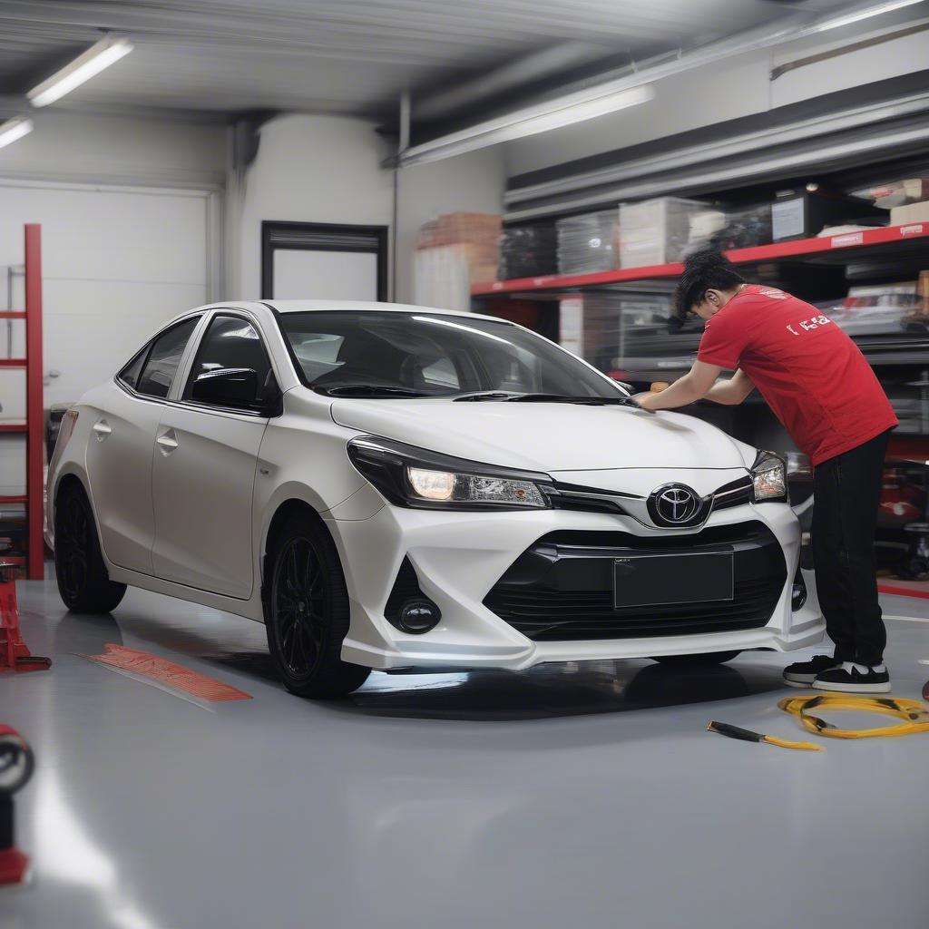 Kỹ thuật viên đang lắp đặt body kit TRD cho xe Vios 2019 tại gara